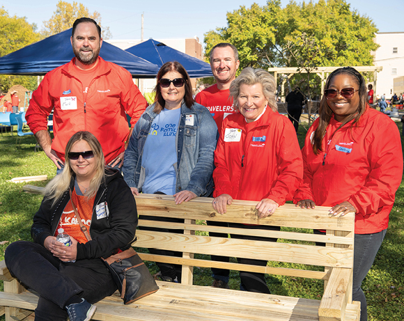 people posing with an unfinished wooden bench